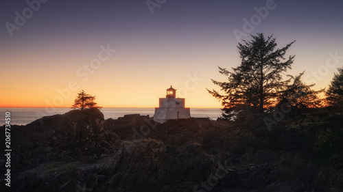 Amphitrite Point Lighthouse at sunset on a rocky headland, Ucluelet, Vancouver Island
