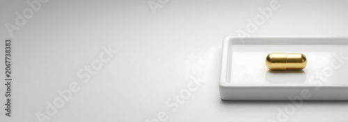 Golden Pill on White Tray with Minimalist Background.
