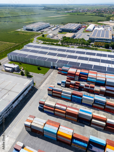 Aerial view of a modern logistics center with solar panels on the roof