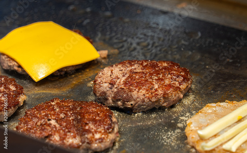 Fotografie Juicy Beef Hamburger Patties Sizzling on a Flat Top Griddle