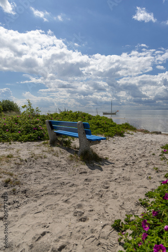Empty blue bench by EuroVelo 10 R10 bike path on sand dunes on Hel Peninsula, Poland
