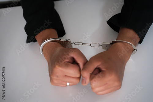 Foto Business woman with handcuffs on a white background
