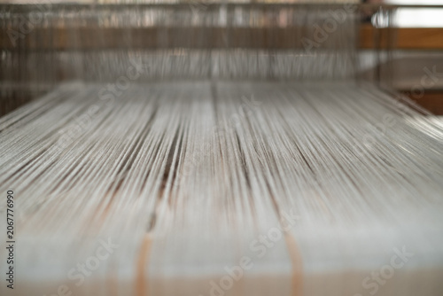 Fotografía Macro shot of fine warp threads stretched tightly on a traditional wooden loom with shallow depth of field