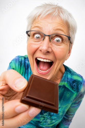 Seniorin freut sich über ein Stück Schokolade