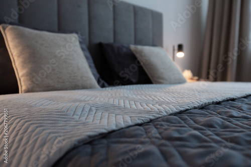 Cozy bedroom with gray quilted bedding and decorative pillows on bed