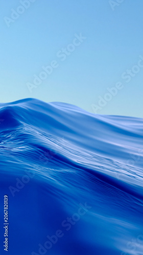 Smooth ocean waves in vivid blue tones transitioning to pale sky blue under a clear sky, creating a serene and tranquil seascape