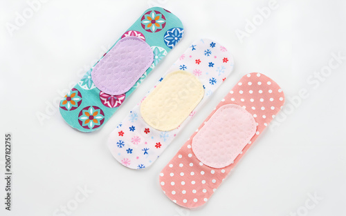 Three colorful patterned adhesive bandages arranged artistically with soft lighting for medical or first aid concepts