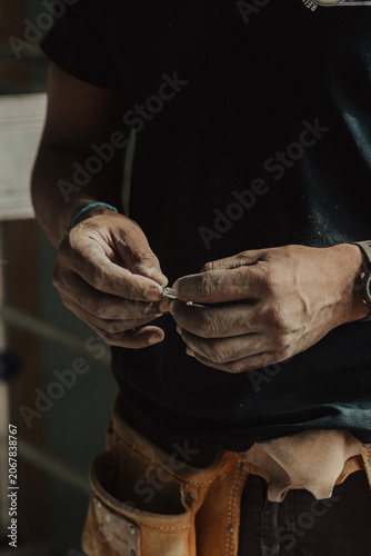 Close-up of construction worker hand holding a screw on building site