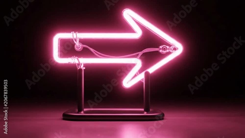 Neon arrow sign glowing with pink light on dark background