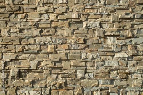 New yellow relief stone tiles on wall closeup