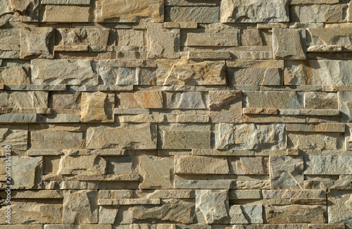 New yellow relief stone tiles on wall closeup