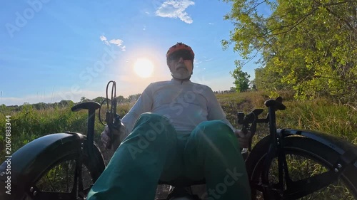Senior cyclist is riding a full suspension recumbent tricycle on a rough gravel trail in northern Colorado - Kyger Open Space