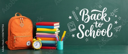 Obraz na płótnie Blue Kids Backpack with Stationery and Alarm Clock Against Yellow Chalk Drawing