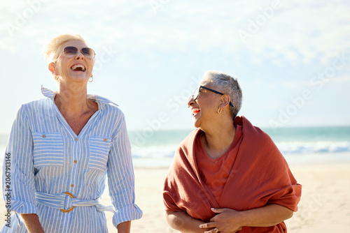 Two Women Laugh Together on the Beach