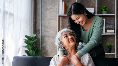 Asian Adult Daughter Giving an Older Mother a Gentle Hug Showing