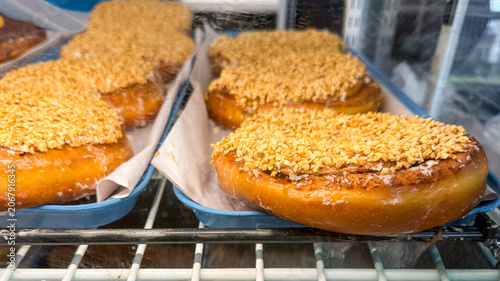 Peanut-Topped Cinnamon Rolls Displayed in Bakery Case