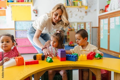 Teacher engaging with children playing building blocks