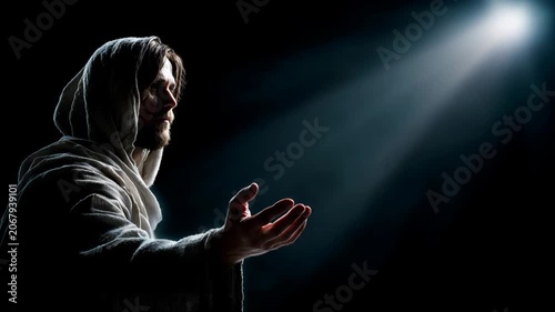 Jesus reaches out in darkness under a beam of light in a quiet moment of reflection