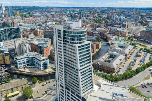 Aerial view of Bridgewater Place dominating the Leeds city centre skyline with Leeds Dock waterways modern offices residential developments and commercial districts under a bright summer sky