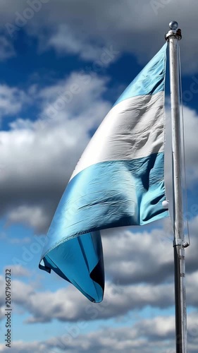 Argentina flag waving in the wind against a bright blue sky, vertical video featuring vibrant national colors, patriotic atmosphere and realistic fabric movement