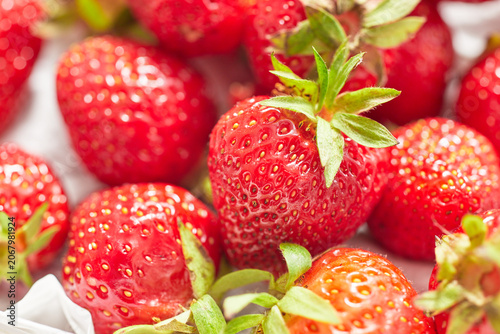 Ripe strawberries grouped on a white paper napkin.