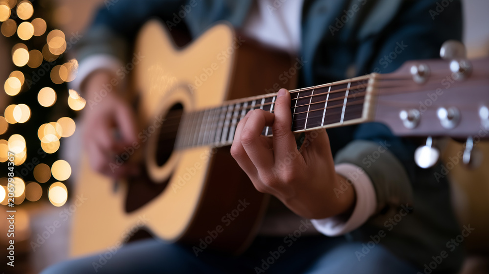 Obraz premium Close-up of hands playing an acoustic guitar, capturing music, creativity, performance and artistic expression in a warm intimate setting.