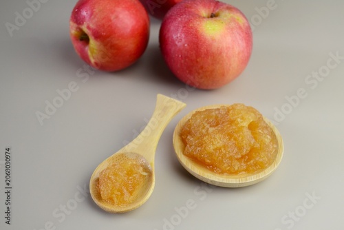 Homemade apple jam in bamboo spoon and bowl with fresh apples