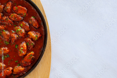 Canvas Print A closeup of plump mussels simmered in rich tomato sauce with fresh herbs, serve