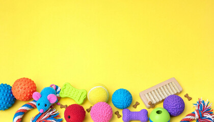 Colorful assortment of pet toys border on yellow background with pet care dog toys pet products background copy-space activity supplies accessories training recreation collection