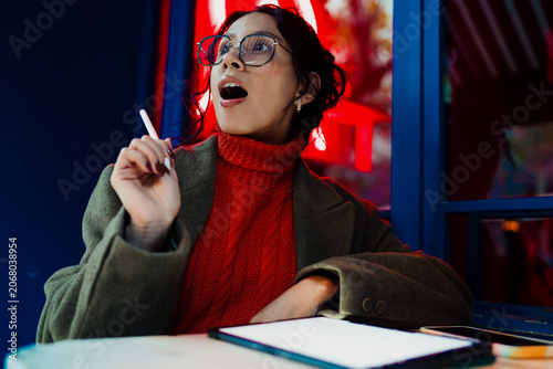 Foto Surprised mixed race woman looking at tablet screen in city evening, amazed expression, winning online notification, amazing news discovery, digital lifestyle, innovation and technology, 5G internet