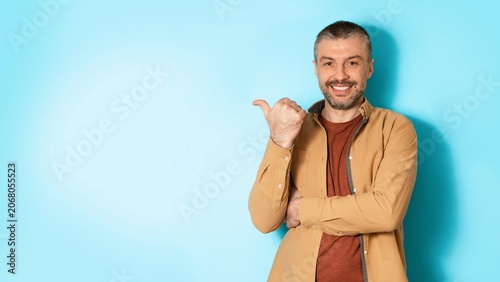 Canvastavla Smiling Caucasian Man In His 30s Giving Thumbs Up Gesture At Home With Light Blue Background, Expressing Happiness And Positivity In Relaxed Setting