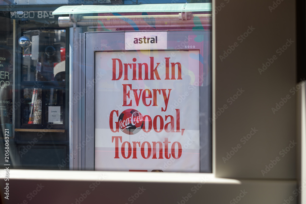 Obraz premium OOH bus shelter advertising poster for Coca-Cola seen from inside a trolley heading eastbound on Dundas St W, Toronto
