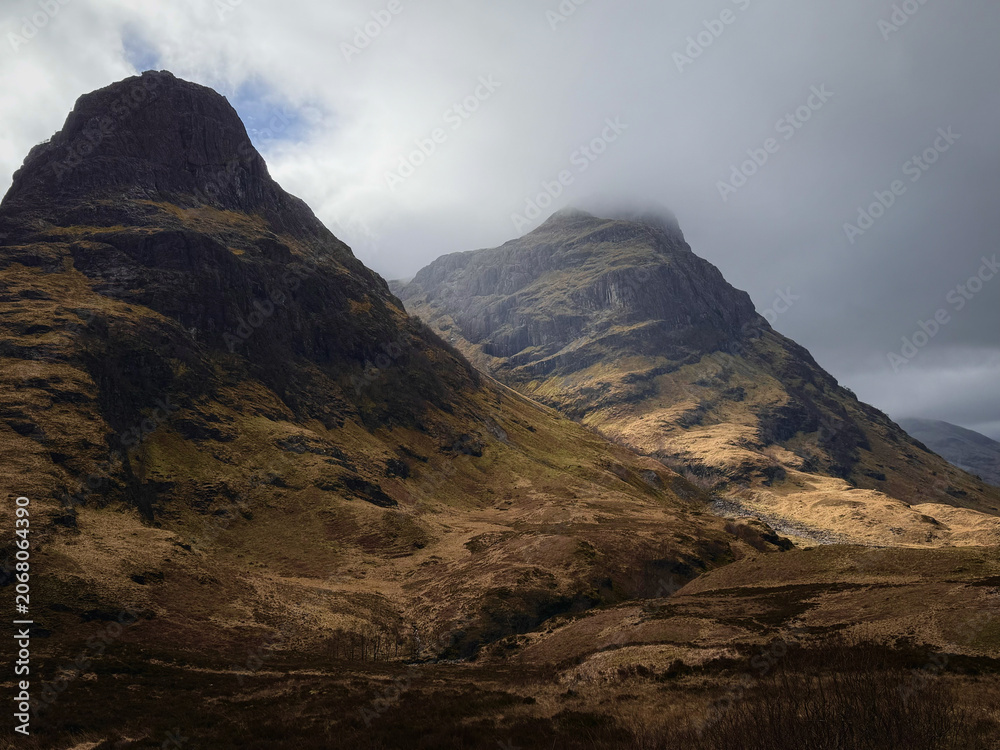 Obraz premium A view of Three Sisters Mountain along the Lost Valley trail in the highlands of Glencoe, Scotland