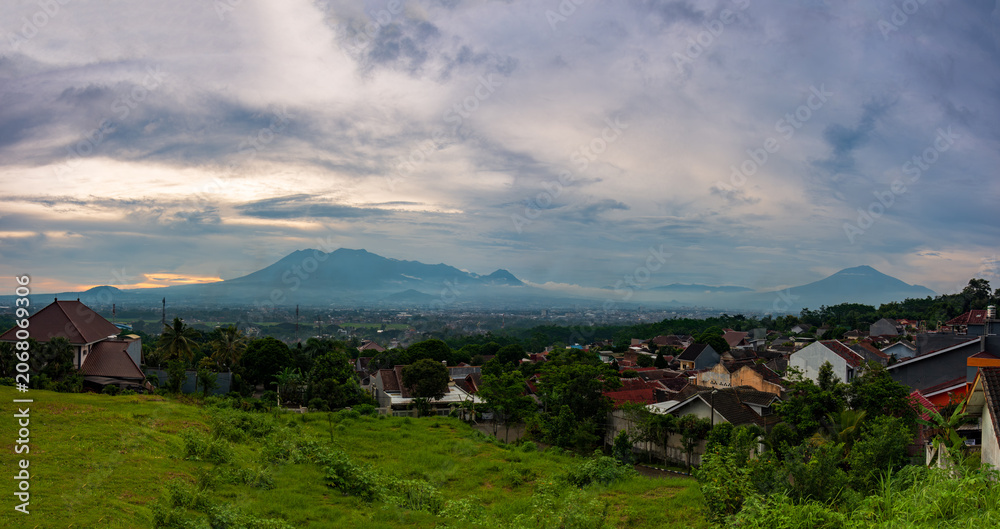 Fototapeta premium Beautiful twilight over Malang city valley with Mount Kawi and Mount Arjuno views at sunset, East Java, Indonesia