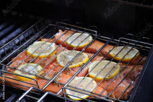 grilled salmon with lemon slices in a fish grilling basket