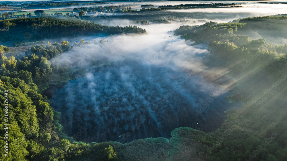 Naklejka premium Mist over lake at sunrise in autumn.