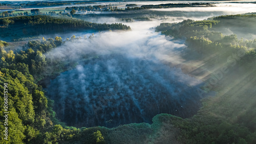 Mist over lake at sunrise in autumn.