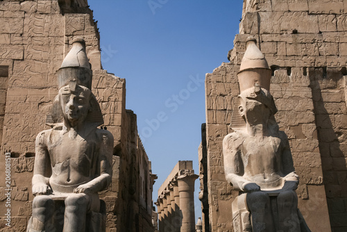 Obraz na plátne Majestic ancient stone statues of Ramesses II guarding the entrance avenue insid
