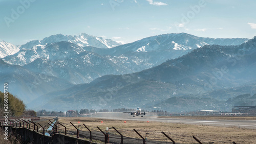 Canvastavla Mountain airport runway with passenger airplane during landing or takeoff agains