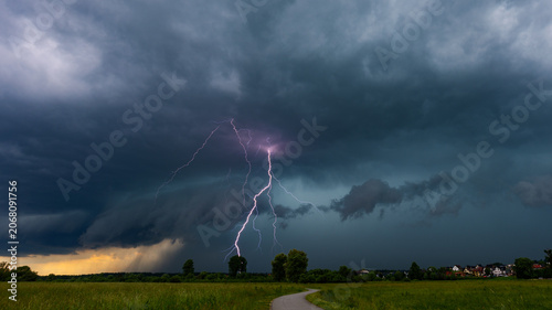 Tableau sur toile Dramatic lightning bolt striking from a powerful shelf cloud during severe summer thunderstorm