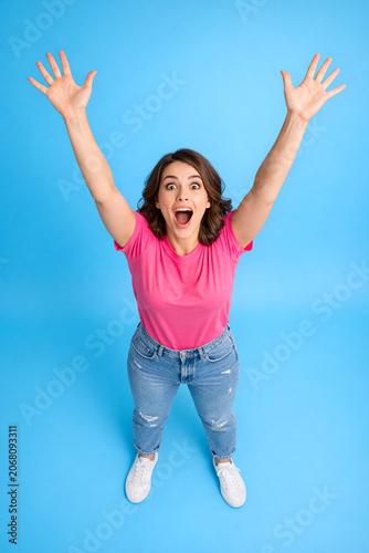 Woman celebrating joyfully on blue background