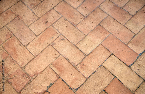 Terracotta herringbone pavement texture, old brick floor background closeup