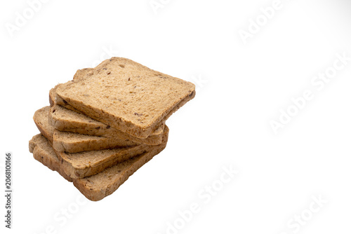 Slices of bread are stacked on one another on a white surface with a plain background