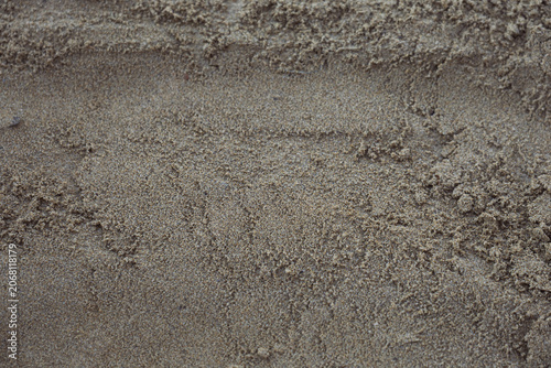 detailed texture of natural brown beach sand with fine grains and subtle ripples