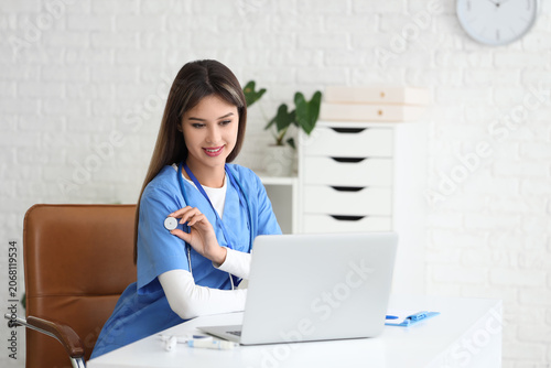 Female doctor with glucose sensor giving online consultation in clinic
