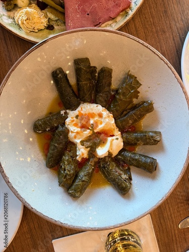 Traditional Turkish stuffed grape leaves sarma or dolma with yogurt and olive oil sauce.