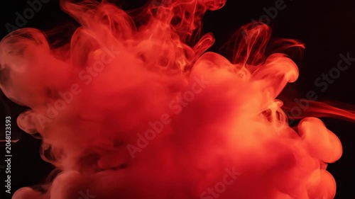 Vibrant red ink cloud swirls and dissipates in dark water, abstract motion