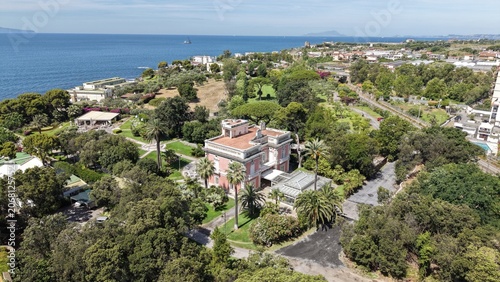 Panoramic view of Villa Guarracino historic mansion surrounded by lush tropical gardens and palm trees overlooking the sea, Torre Annunziata, Naples, Italy
