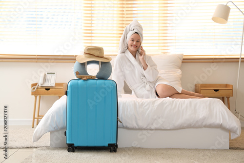 Female tourist talking by mobile phone after shower in hotel room