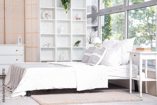 Interior of bedroom with tables, shelf unit and drawers